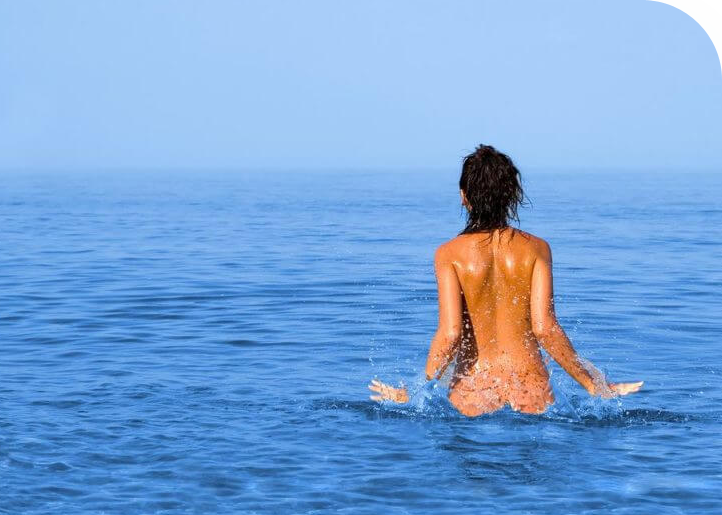 naked girl swimming on nudist beach in Split Croatia